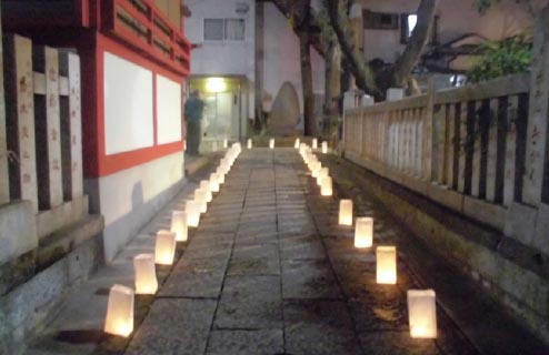 「お焚き上げと参道の灯かり」
